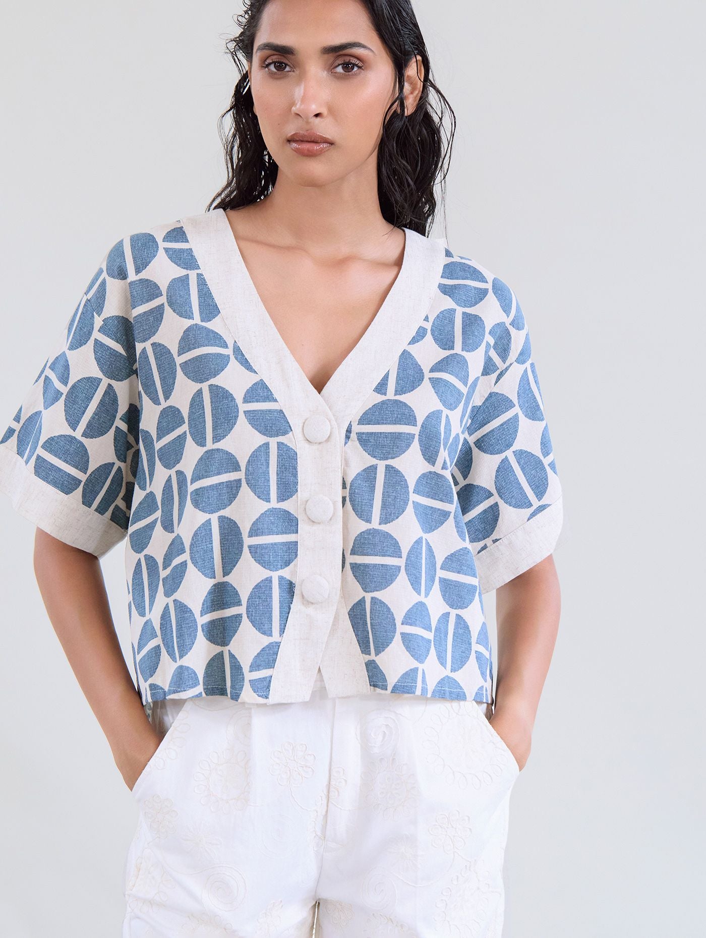 This stunning piece from Scandi brand SKATIE is a great piece that will work hard in any Summer wardrobe. A short box piece that works well with a wide leg trouser or full skirt. The V neck flatters and there are 2 fabric covered buttons to fasten.The short sleeves and neckline are trimmed in a beautiful neutral.