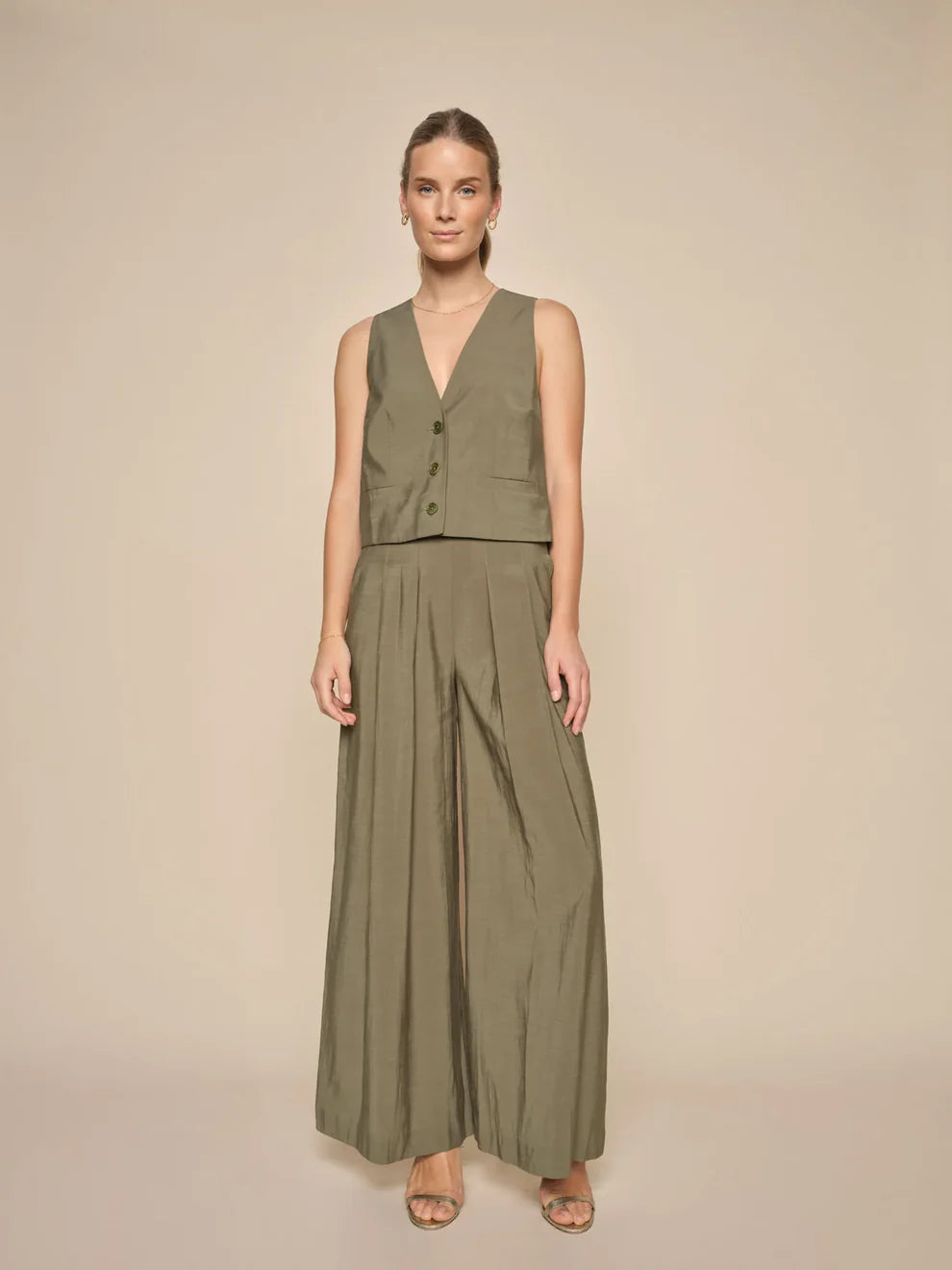 These eye-catching pants have a high-waisted, wide-legged silhouette designed in a long length. Crafted with an elasticated waist and a side zipper closure, they also feature delicate pleats for added elegance.