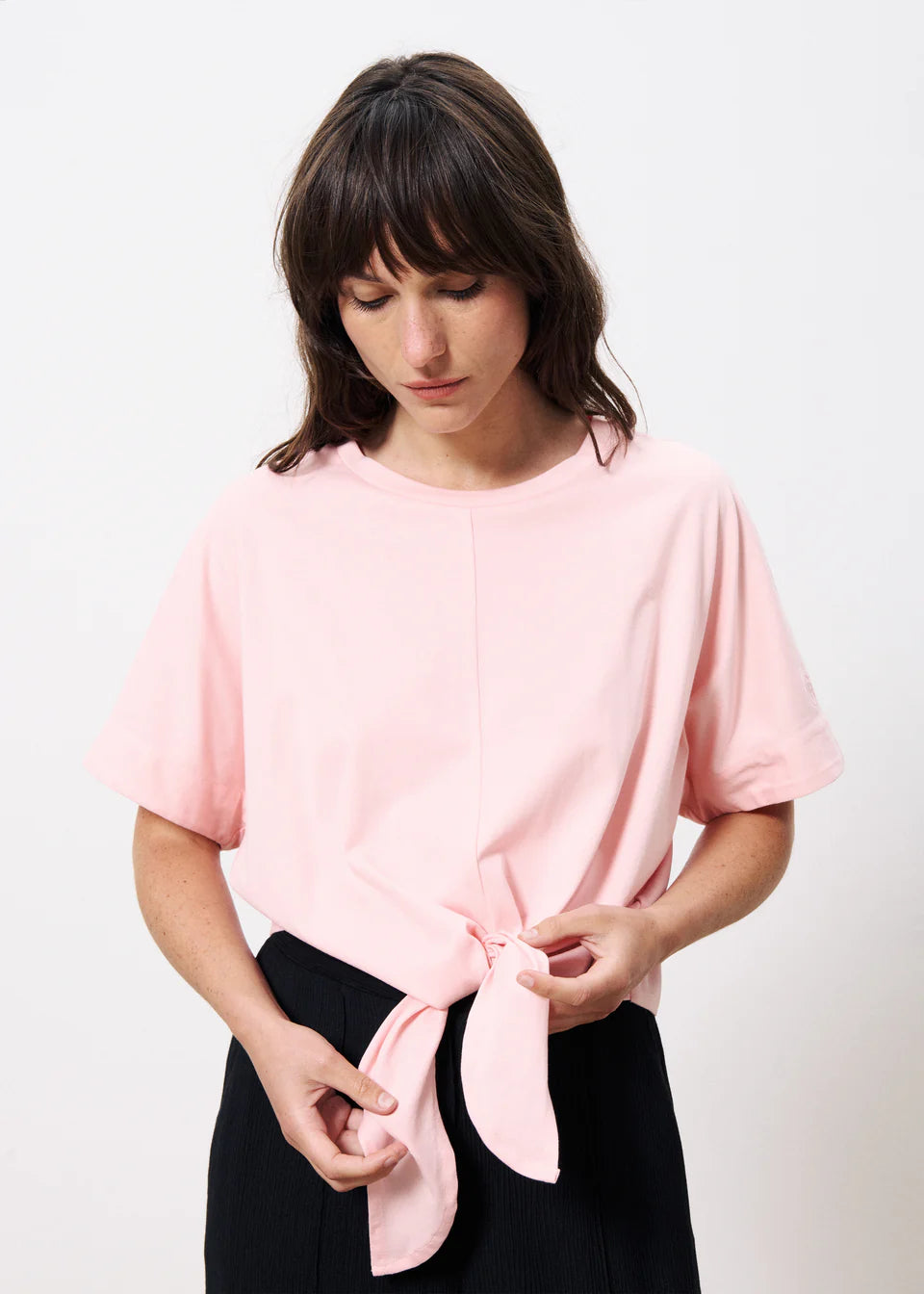 A simple round neck T shirt from Parisian brand FRNCH with a tie waist to war with a full skirt or wide leg trousers for that cool look. The sleeves are short and there is a centre seam down the front from the neck to the waist. A great Summer staple in two fab colours. The fit is true to size.