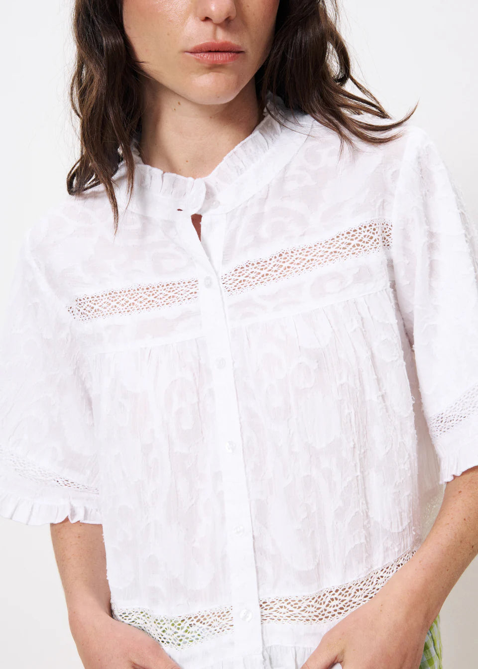 The FRNCH Einat Shirt in Creme, a short-cut, casual, short sleeved, pretty bohemian blouse with a ruffle collar and lace inset detail. Buttons to the front and the fit is short and boxy and neat in size.