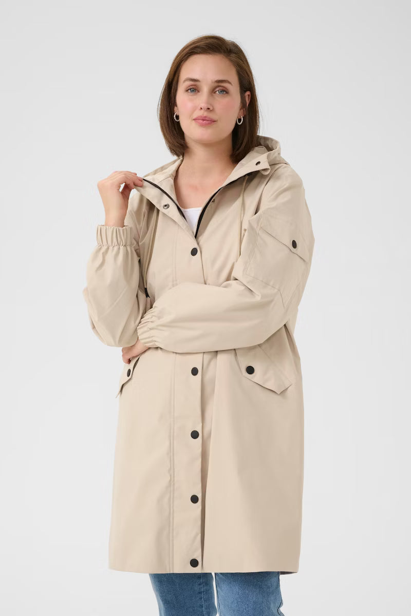 Long hooded jacket from KAFFE with relaxed fit, snap-button closure, drawstring at hood, and practical flap pockets. Elastic cuffs complete this streamlined outerwear essential.