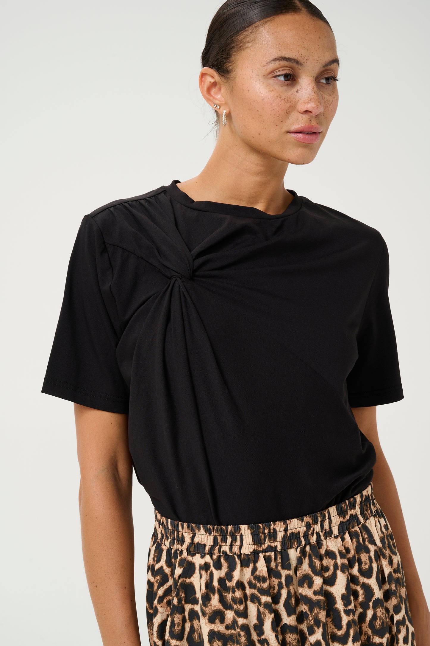 A great T shirt with that little point of difference from Scandi brand KAFFE. With a round neck this T shirt is boxy with a twisted fabric detail on one side. A very flattering shape which fits true to size.