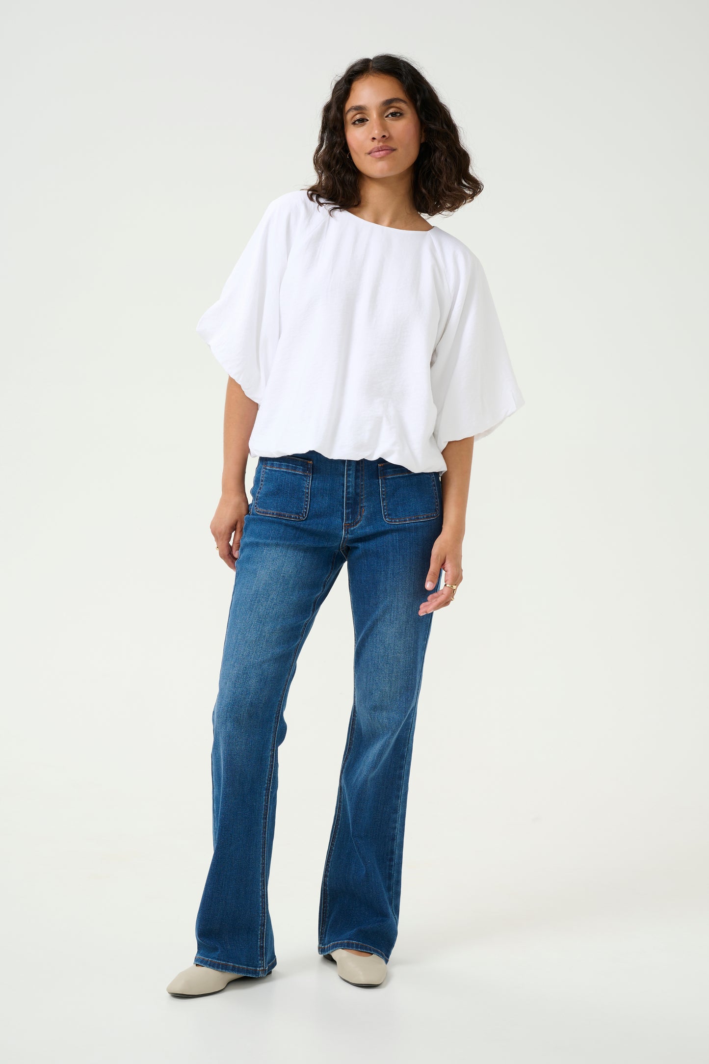 A super stylish blouse from Scandi brand KAFFE in optical white. This gorgeous round neck piece has a single button fastener at the back. The sleeves are puffed with a slightly elasticated cuff to fit the arm perfectly. The hem is gently elasticated and the blouse is fully lined. The fit is true to size.