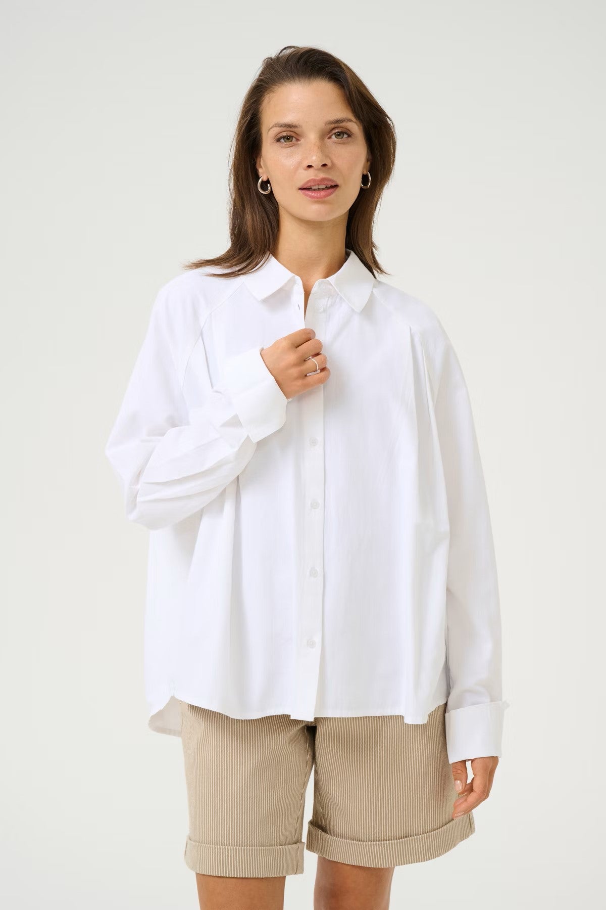 A chic white blouse from KAFFE for Spring that works beautifully with a pair of shorts as well as denim. The dropped shoulder is super flattering and the slight pleating on the front adds that point of difference. The long sleeves have a long cuff that can be worn down or turned back. There is a simple shirt collar and rounded hem. The fit is true to size.