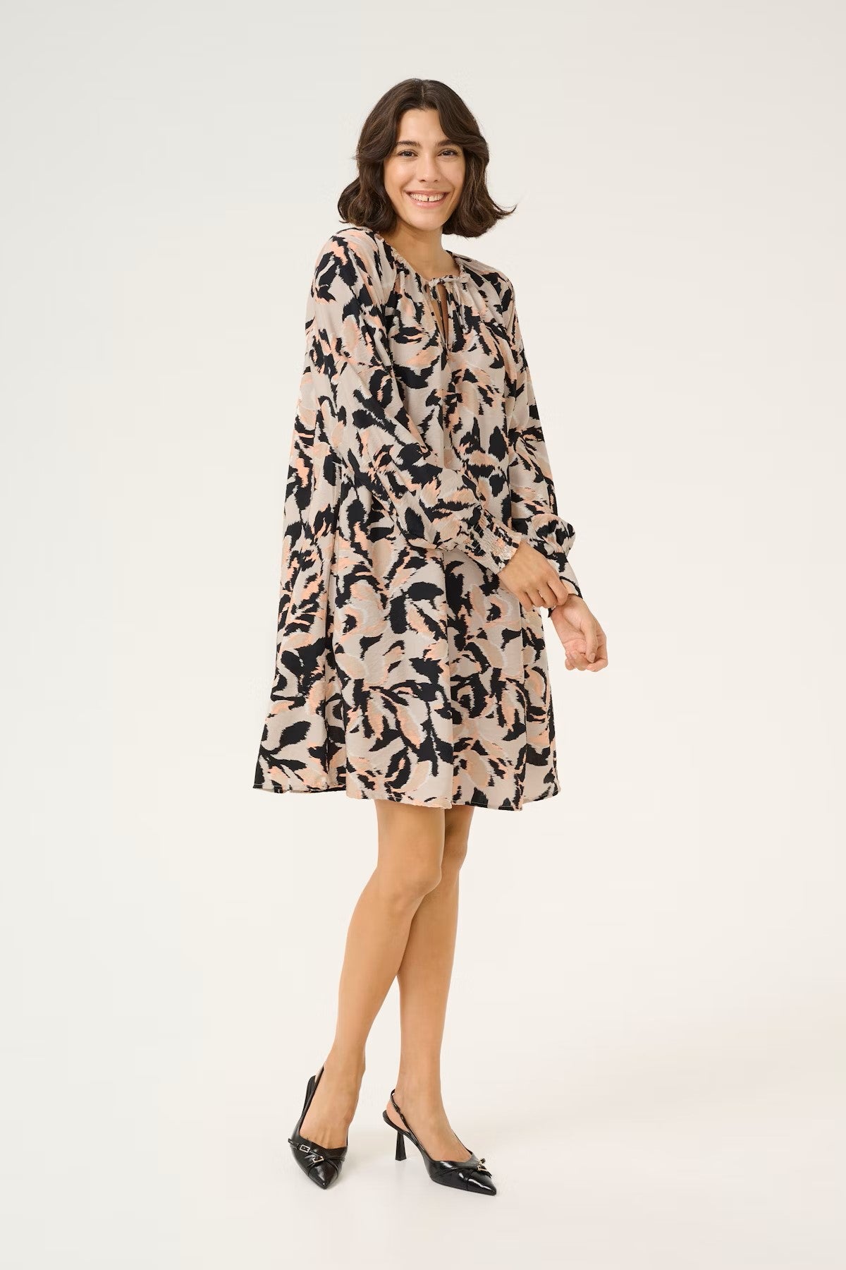 The short KAPaco dress from KAFFE is a stunner for those who prefer a shorter flattering length dress. A shaped and loose fitting this will be cool in the warmer months. There is an open neck with tie fasteners. The long sleeve has a half elasticated cuff which is super flattering and there are pockets in the side seams. The fit is true to size.