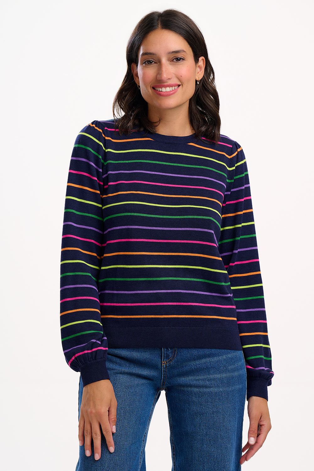 The Madeline Jumper from SUGARHILL features a semi-fitted silhouette in a soft, lightweight knit, perfect for layering. Classic yet playful, it showcases evenly spaced rainbow stripes across a rich navy base, giving it a fresh, modern minimalism. Ideal for everyday wear, this versatile striped jumper pairs effortlessly with denim jeans or a denim skirt for an elevated casual look.