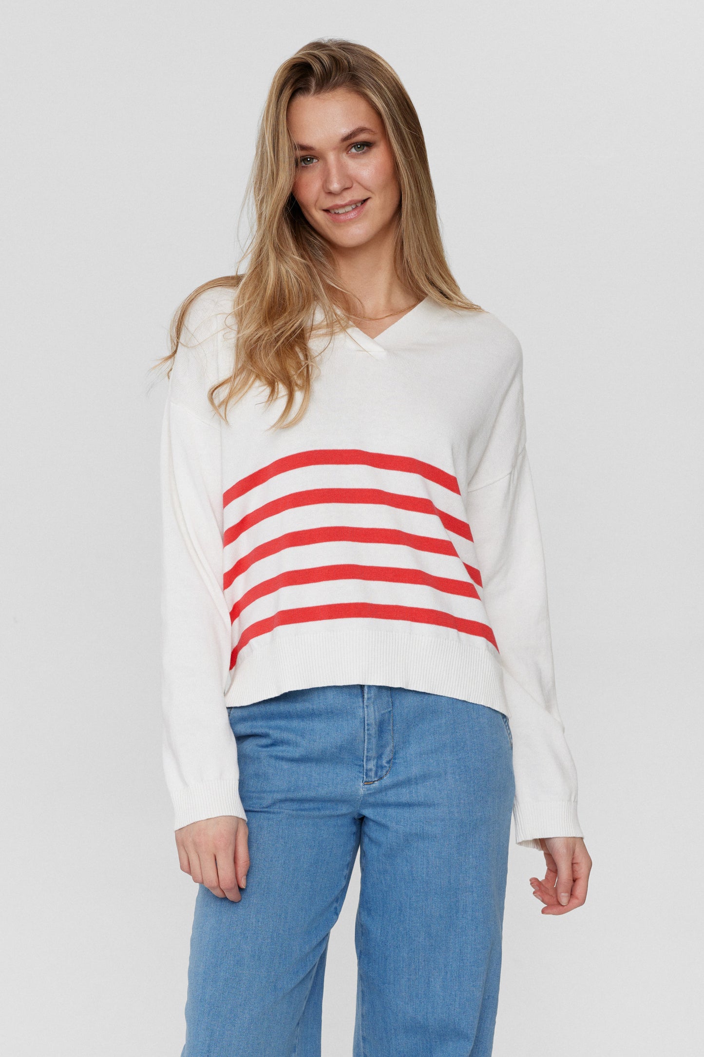 A boxy V neck jumper from Numph . This great knit is a boxy shape with long sleeves with a wide ribbed cuff. There are small splits at the hem either side . There are three buttons on the left shoulder to add that extra little something. The fit is true to size but it is a shorter length piece.