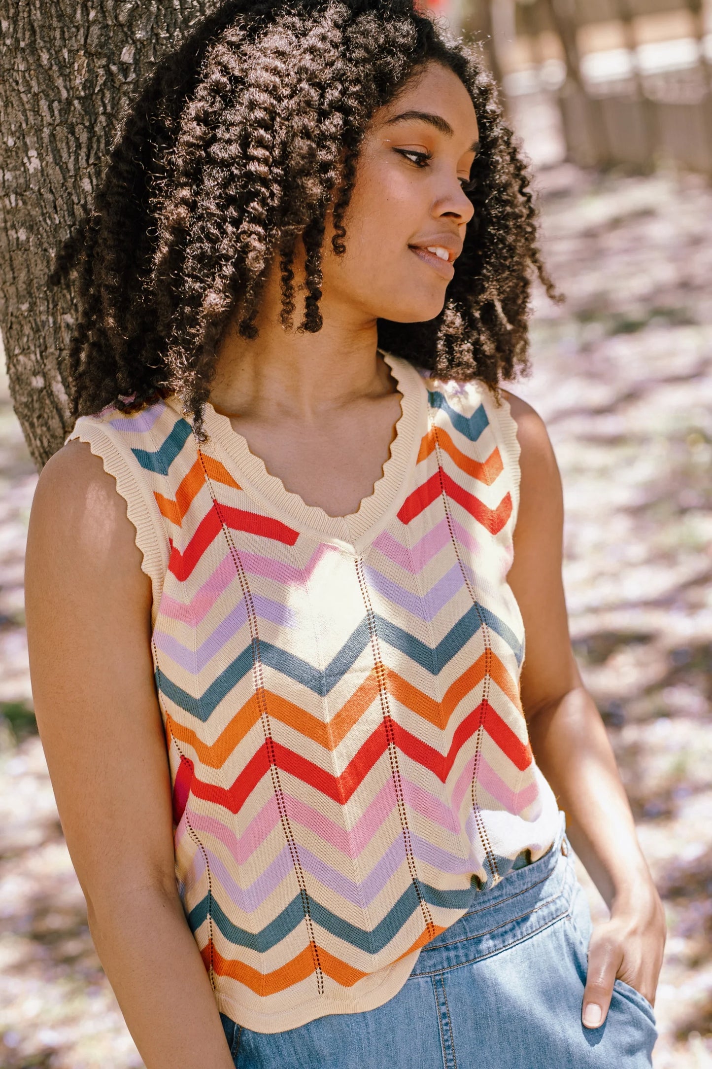 New for 2025, the Rosy Knit Vest from SUGARHILL is a V-neck sleeveless top with wavy hems and pointelle detailing. Inspired by the summers of the 70s. Featuring a chevron design in orange, red, pink, lilac and teal. Pair with your fave denim for a perfectly casual outfit.