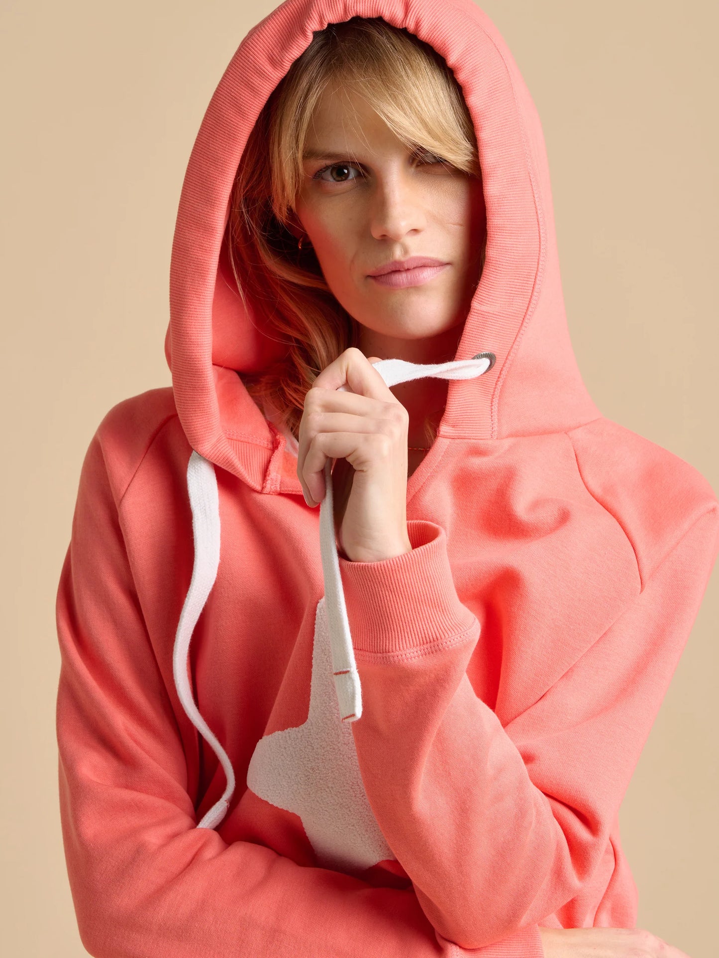 A great piece for Summer from UK brand BRAKEBURN in a super soft fabric perfect for every day wear. A bright coral hooded sweatshirt with straight hem with side splits. The fit is true to size.