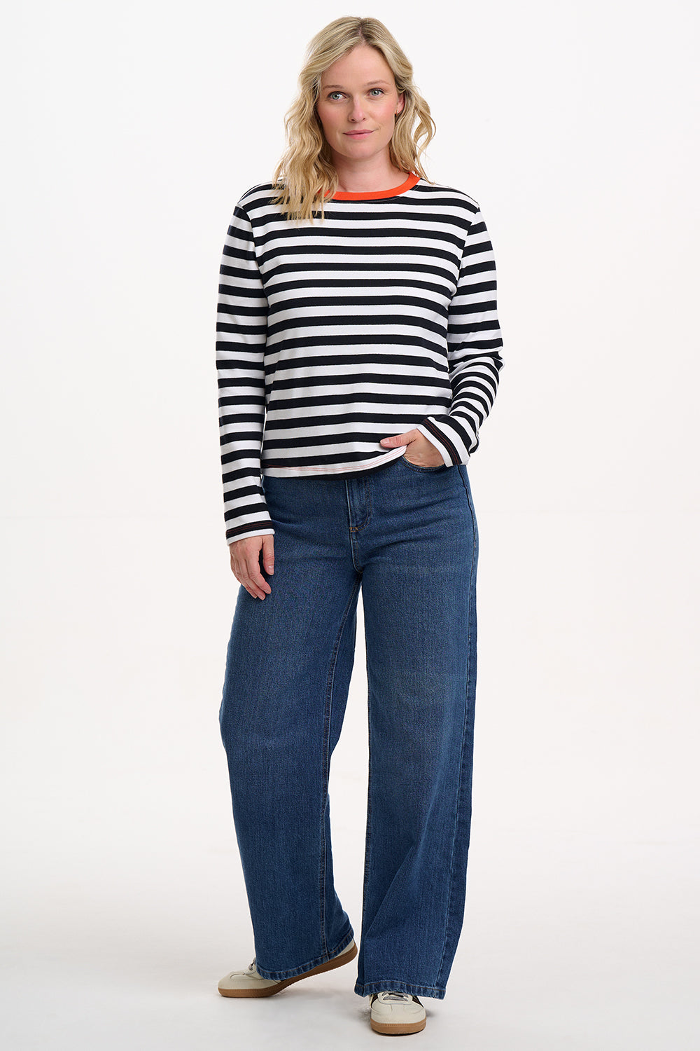 Elevate your everyday style with the Vienna Jersey Top from SUGARHILL in White and Black Stripes. This classic long-sleeve Breton top features bold horizontal stripes on soft jersey fabric, finished with a statement contrast neckline in vibrant orange for a playful twist. The relaxed fit and crew neck make it an effortless layering piece for jeans, skirts, or under dungarees—perfect for casual days and weekend wear.