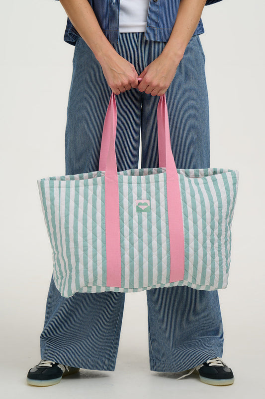 Meet our new Quilted Tote Bag from SUGARHILL! This bag will fit all your essentials and more with a wide gusset base and sides. This large cotton quilted bag features a pastel green vertical stripe over an off-white base, with baby pink straps. Whether you're packing it full of beach holiday essentials or taking it to the gym, this shopper bag won't let you down.