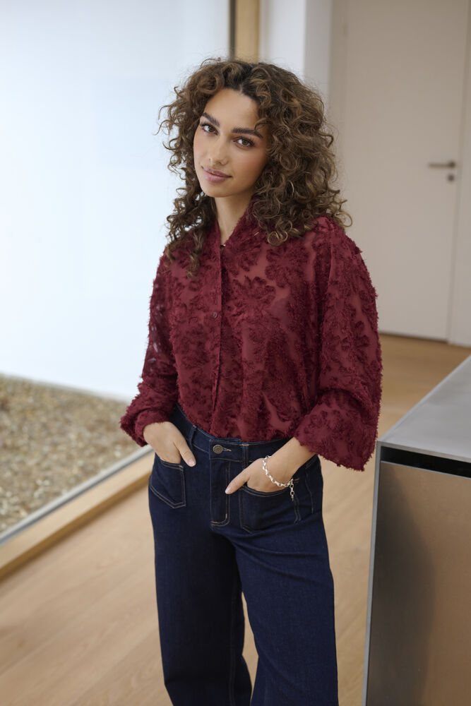 This beautiful blouse from KAFFE is in a rich port colour. A classic shirt shape with a textured flock style embossed print all over. The classic collar can be worn buttoned or open at the neck. The long sleeves have a double button cuff. This could be worn for an occasion with a smart trouser or with denim more casually.
