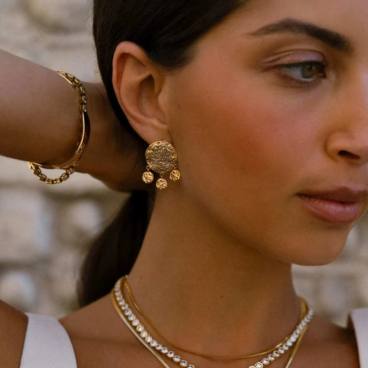 A modern mix of texture and movement, the Molten Coin Shaker Earrings from ORELIA feature a single bold coin stud paired with three delicate mini coin charms.