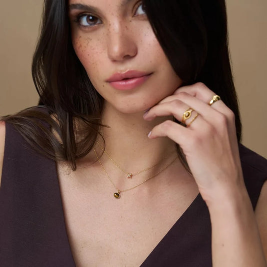 Framed in a sleek gold-tone setting and suspended from a delicate chain, this Semi-Precious Tiger's Eye Charm Necklace from ORELIA adds warmth, richness, and an effortless statement to any look.