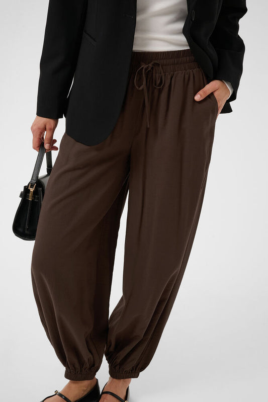 These relaxed fit jogger pants from KAFFE feature an elasticated waistband with drawstring, gathered ankle cuffs, and a soft fluid texture for effortless style. The fit is true to size.