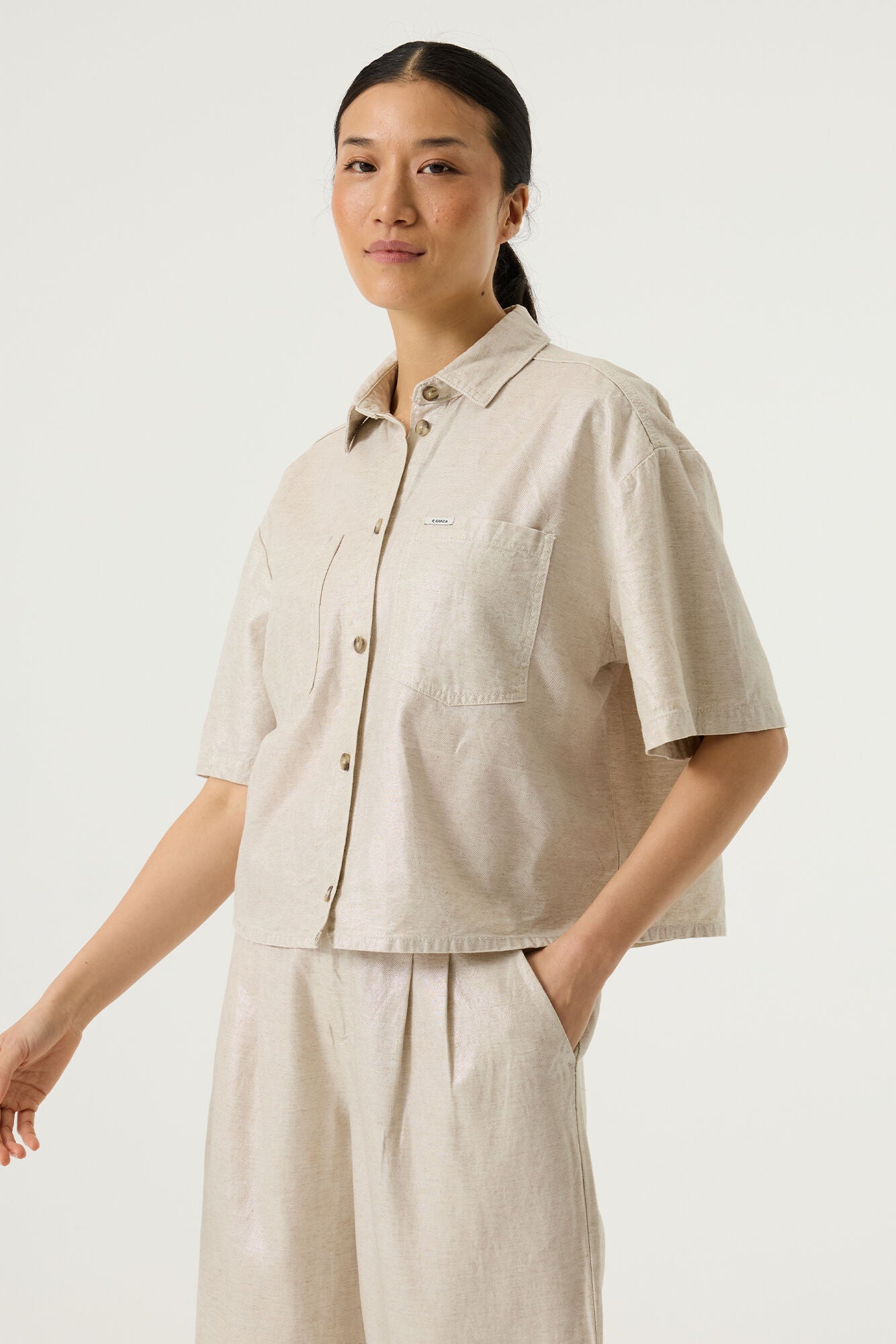A boxy shirt from GARCIA in a beige coated fabric. Cropped and with a sort sleeve this is a really useful piece for Spring. Wear open as a jacket too. The boxy fit is true to size.