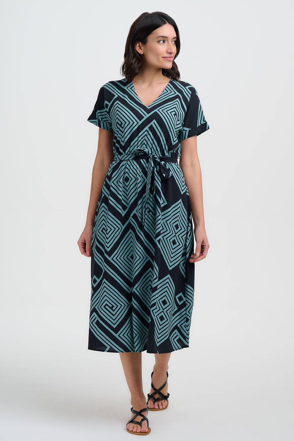 Meet Bethan from SUGARHILL — your new favourite summer statement dress. Designed with a short sleeves, a flattering V neck, and a flowing midi length skirt, this style combines comfort and charm in equal measure. Like all the best dresses, it has pockets! The teal geometric spirals and diamonds print create a bold, maze-like pattern on a black background, making it the perfect trans-seasonal piece for brightening any day.