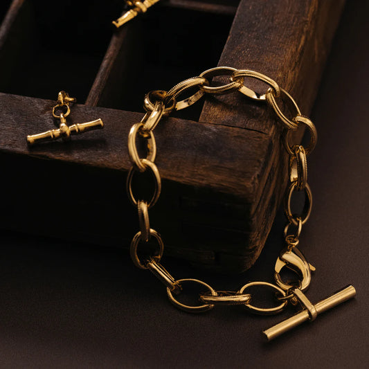 The Oval Link T-Bar Drop Bracelet, is a timeless piece featuring elegant oval links connected at the clasp, with a T-bar drop charm. The drop design adds a touch of movement and security, making it perfect for everyday wear.