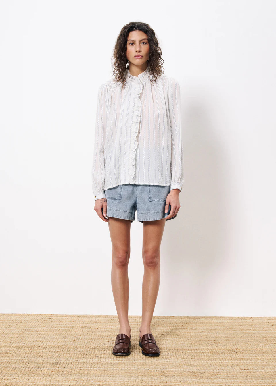 This beautiful semi sheer shirt from Parisian brand FRNCH is stunning for a hot holiday or for the warmer Summer weather. With a frilled collar and placket and long sleeves it looks great with denim. The fabric has a pale blue stripe throughout. The fit is true to size.