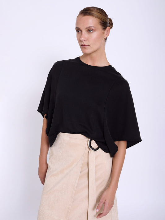 A simple black T shirt weight top from Scandi brand SKATIE. Boxy in shape and cropped with a wide elbow length sleeve. Perfect with a full skirt or loose fit trousers or jeans.