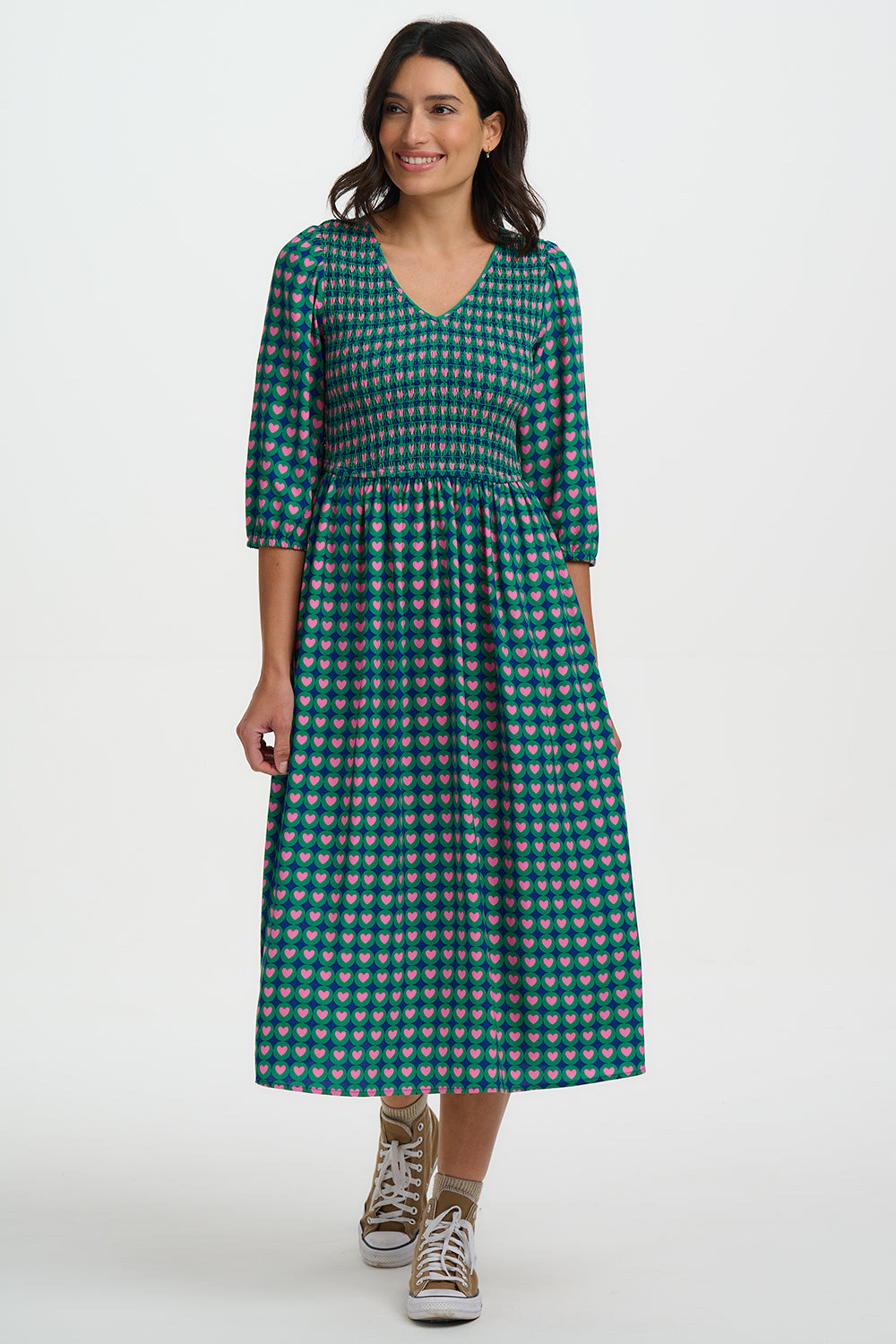 The Della Shirred Midi Dress from SUGARHILL is a feel-good statement piece with an easy, flattering fit. Featuring a softly shirred bodice, V-neckline and comfortable ¾-length sleeves, it flows into a relaxed midi skirt that moves beautifully. The bold retro heart print—pink hearts set within green circles on a navy base—adds playful charm, making it perfect for everyday wear with trainers or dressed up with boots.