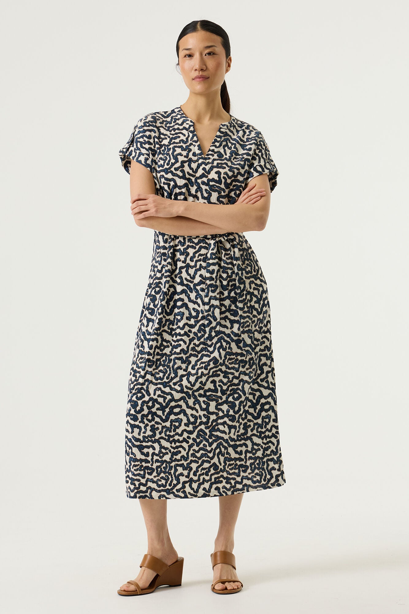 A lovely V neck dress with capped sleeves from GARCIA. With an elasticated waist this dress is a perfect fit. It in midi length with a small split at each side. Perfect for day wear but also easily dressed up for an occasion. There is a slight stretch in the textured fabric and it has a tie belt.