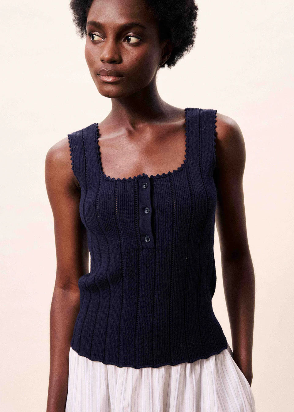 Ribbed knit tank top from FRNCH with central button fastening and scalloped trim. Sleeveless piece that is cropped and fits t