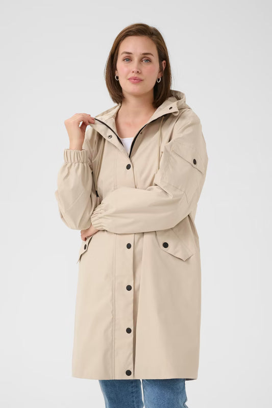Long hooded jacket from KAFFE with relaxed fit, snap-button closure, drawstring at hood, and practical flap pockets. Elastic cuffs complete this streamlined outerwear essential.