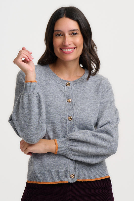 The Glinda Cardigan from SUGARHILL is a charming and feminine style with a classic round neckline and button-front design. It features a lovely orange trim along the hem and cuffs, while the gold-coloured heart-shaped buttons add a sweet finishing touch. Made from 67% acrylic, 30% nylon and 3% elastane, the Glinda is a versatile cardigan that's perfect for adding a pop of colour and personality to any outfit.