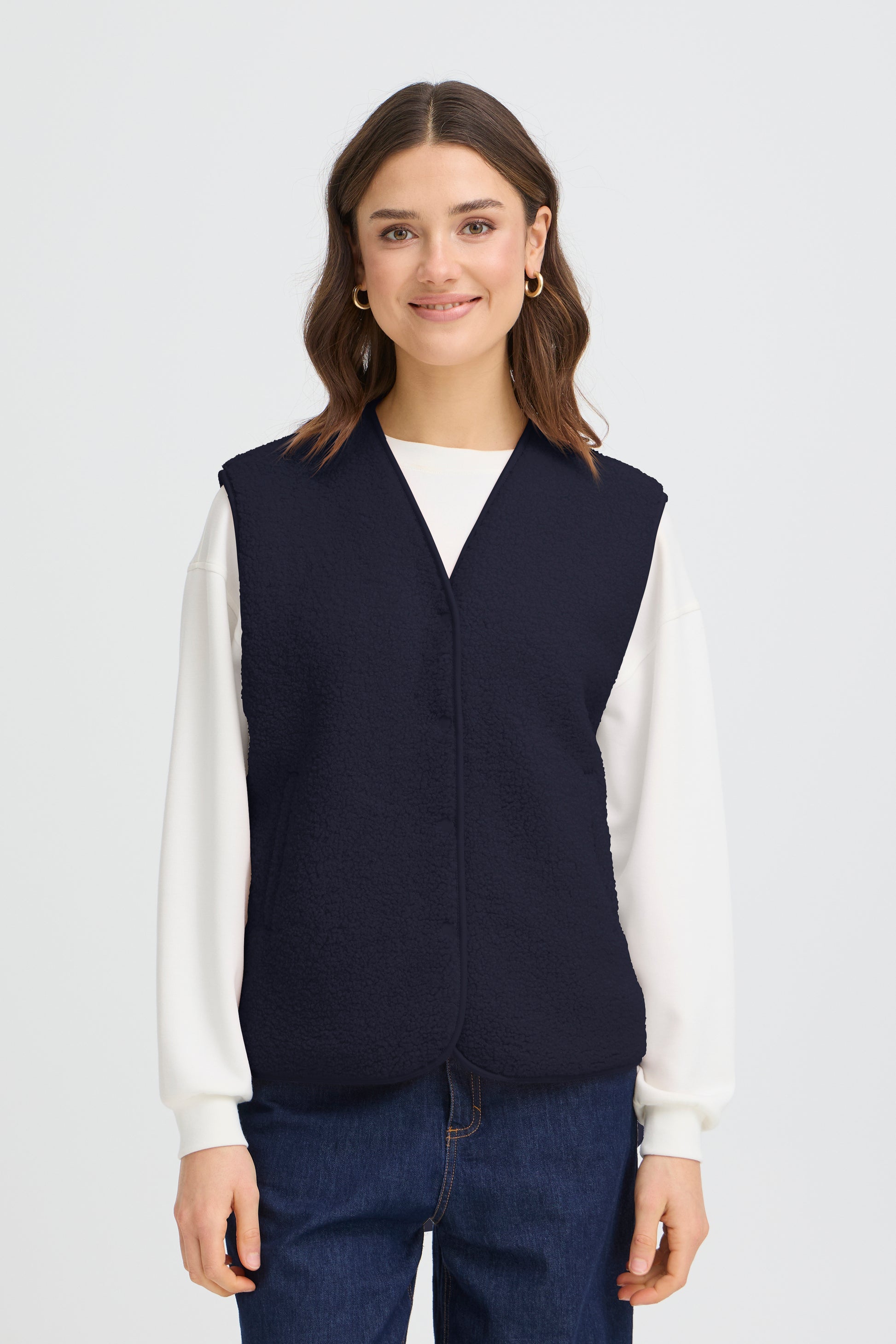 Women's fleece vest from FRANSA offers relaxed fit and versatile style for layering. Features a V-neckline, snap button closure, and soft, textured finish for all-day comfort. Ideal for casual or semi-casual outfits. Fits true to size.