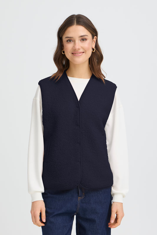 Women's fleece vest from FRANSA offers relaxed fit and versatile style for layering. Features a V-neckline, snap button closure, and soft, textured finish for all-day comfort. Ideal for casual or semi-casual outfits. Fits true to size.