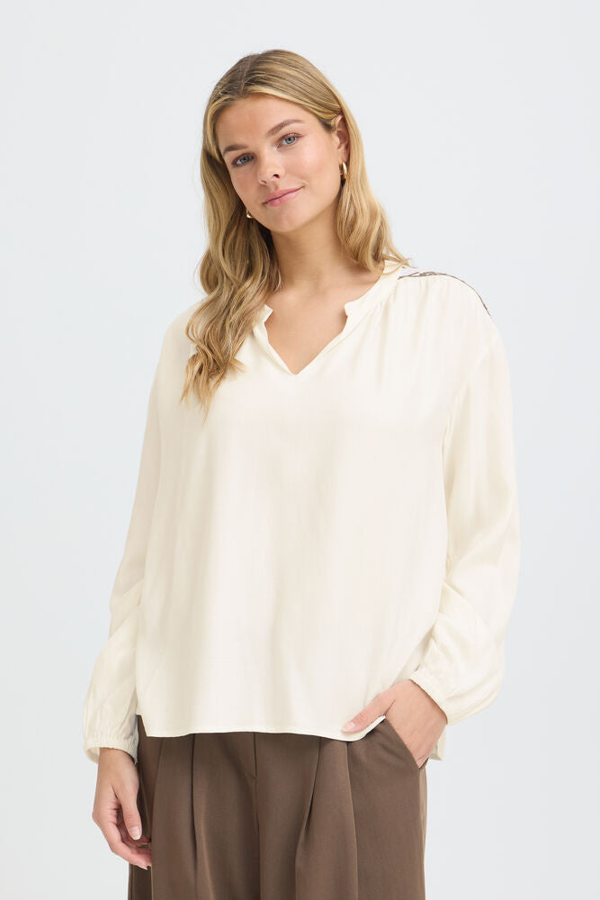 Effortless blouse from FRANSA with a subtle soft finish, relaxed silhouette and flowy drape. Features a split neckline and long gathered sleeves for a refined touch.