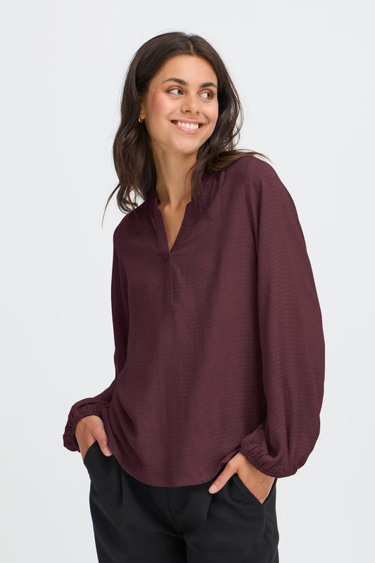 This women's blouse from FRANSA features a relaxed fit, V-neckline, and long sleeves with elastic cuffs. Its simple silhouette and versatile design offer comfort for both work and casual wear. Ideal for effortless, everyday styling. The fit is true to size.