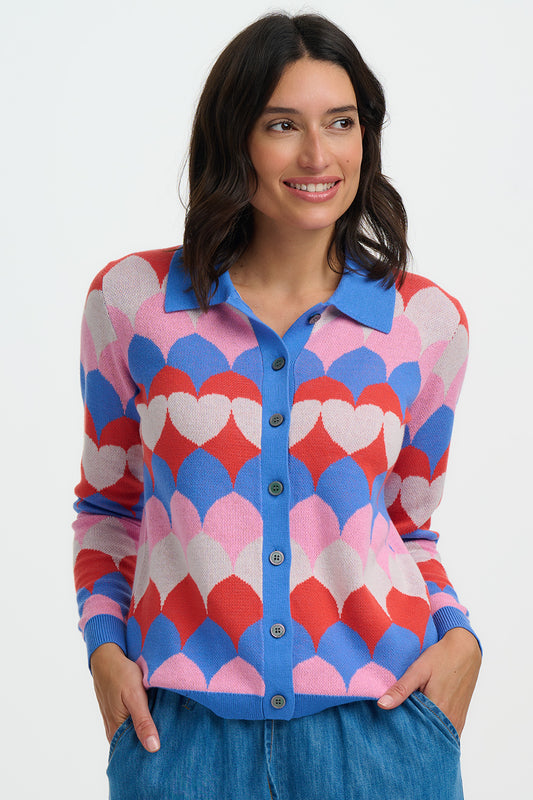This standout cardigan from SUGARHILL brings playful retro charm to your knitwear collection. Designed with a flattering semi-fitted shape, button-through front and classic collar, it features a bold scalloped heart pattern in vibrant shades of orange, blue, pink and cream. Soft to the touch and easy to style, it’s perfect for adding colour and personality to everyday outfits.
