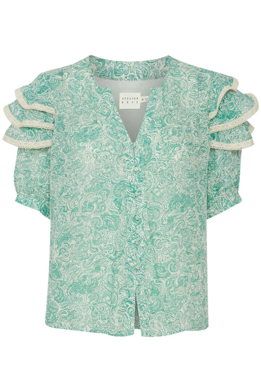The IRLivou blouse from Atelier Reve is typical of their feminine style. A notch neck blouse perfect for bigger busts in a soft paisley style print. There are fabric covered buttons to fasten from the bottom of the V to the hem. The sleeves are the perfect length and have a lace trimmed frill over the shoulder. The sizing is generous.