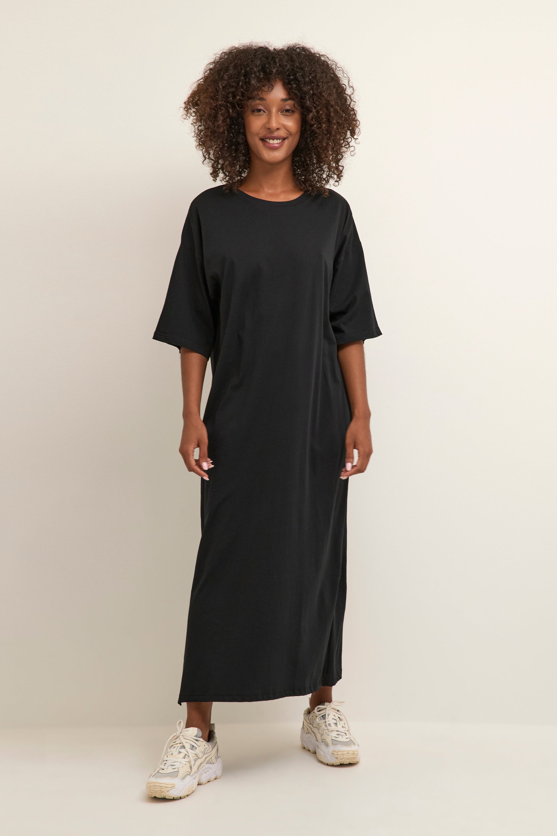A simple pull on dress for Summer from KAFFE clothing. A straight and simple piece in a longer length with short sleeves. The fit is true to size. Side splits.