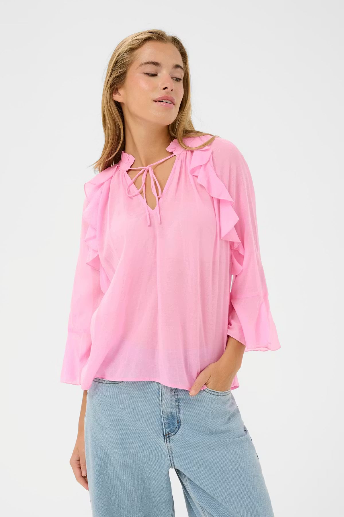 Ruffle blouse from KAFFE features a loose silhouette with a round neckline and tie detail. Ruffled edges run along the front and sleeves, while the three-quarter sleeves have a flared finish. Lightweight texture gives it a soft drape.