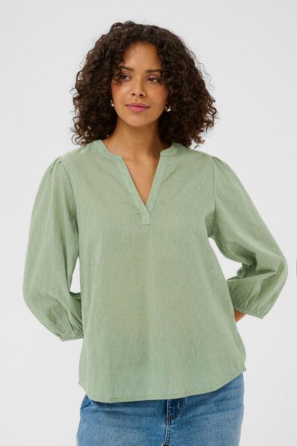 Elevate your everyday wardrobe with this sophisticated v-neck blouse from KAFFE in a serene sea spray green. The relaxed short sleeves offer effortless comfort, making it perfect for layering or wearing solo. Its timeless silhouette transitions seamlessly from office to weekend, while the soft fabric drapes beautifully against the skin. A versatile essential that pairs with everything, this blouse delivers understated elegance with genuine wearability.