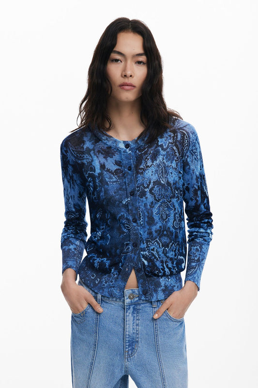 A fitted fine cardigan from Spanish brand DESIGUAL. Front buttoning, and round neck in fabric with a shiny finish. Round at the neck and long sleeves with ribbed cuffs and hem. The fit is neat.