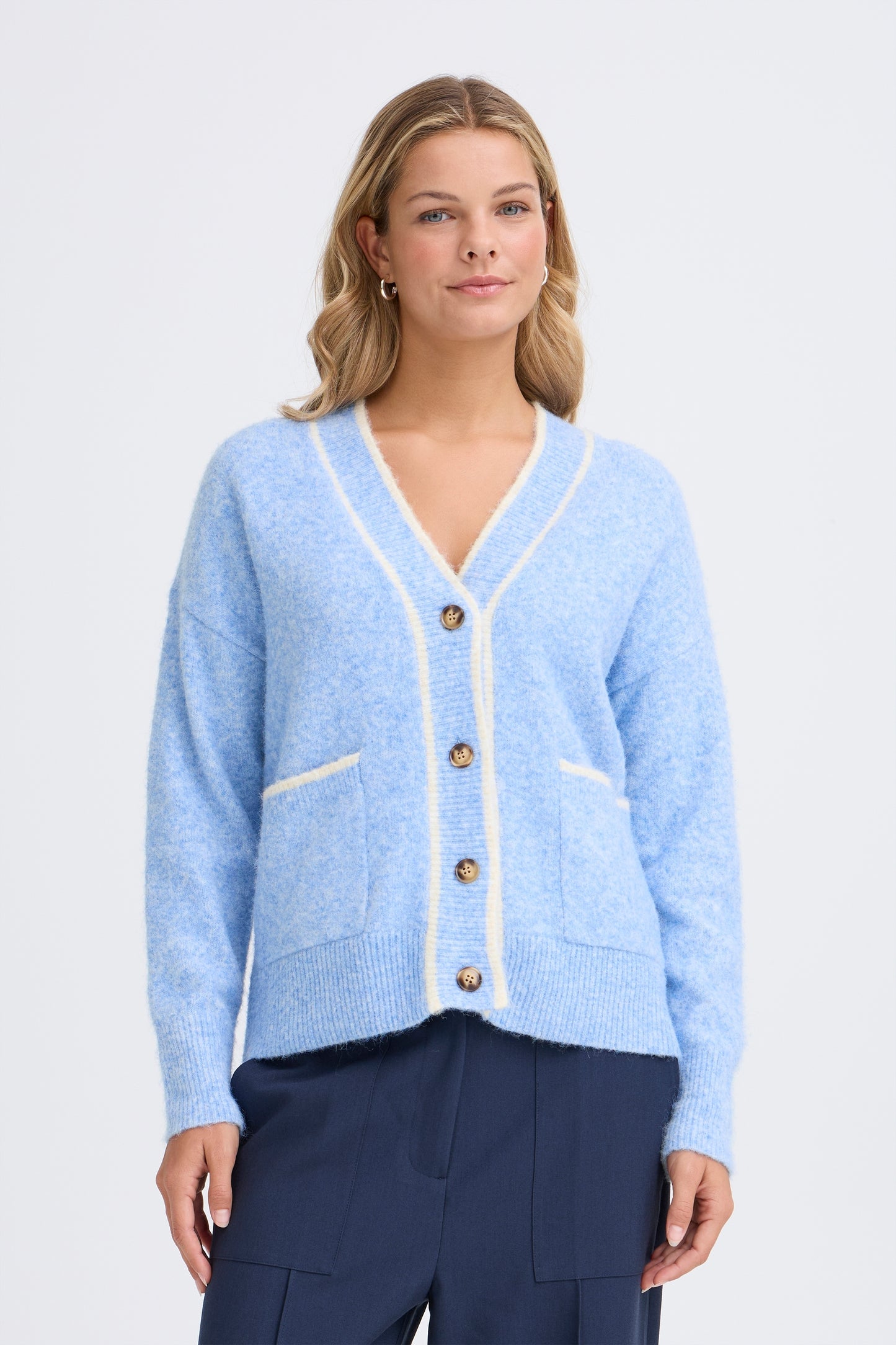 The Kendra Cardigan in the fresh blue is a great slouch type cardigan from Scandi brand FRANSA. The flattering V neck cardi has long sleeves with cream trim and two patch pockets to the front. The knit fastens with contrasting buttons and is in a super soft fabric.