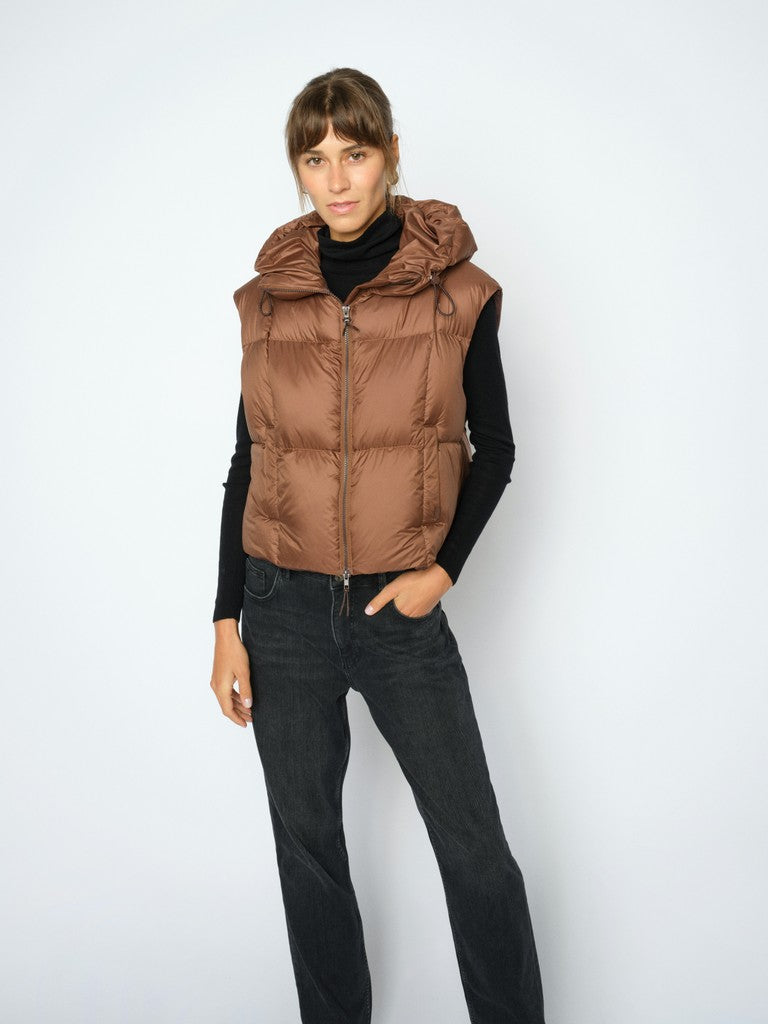 A modern layering piece from MOS MOSH is designed with a sporty feel and a relaxed silhouette. This padded waistcoat features a cosy hood, a front zip fastening, and a slightly cropped shape that makes it easy to style over chunky knits, sweatshirts, or lightweight jackets.