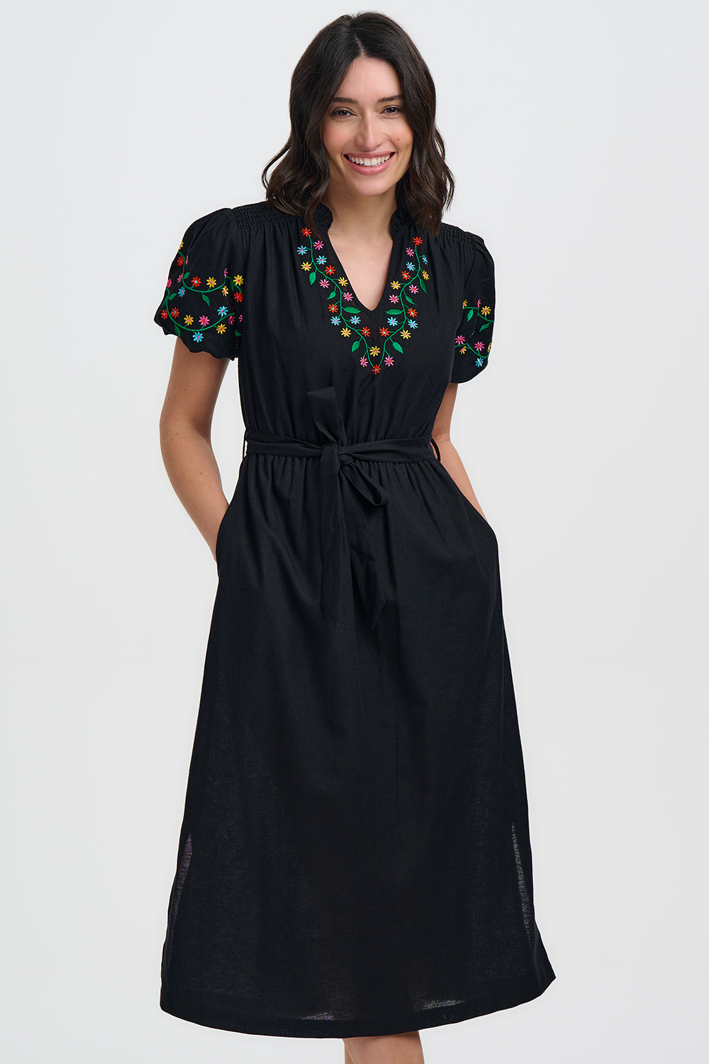 A super pretty midi dress in classic black from SUGARHILL Brighton. The pretty notch neck is trimmed with coloured floral embroidery and the shoulders are gently gathered. The short sleeves are puffed and elasticated and embroidered too. The waist is elasticated and there is a self tie belt and side pockets. The fit is true to size.