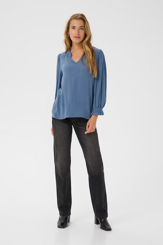 Relaxed blouse from KAFFE with a comfortable loose fit, featuring a V-neckline, long balloon sleeves, and delicate ruffle trim. Ideal for work or casual occasions, designed with versatility and all-day comfort in mind. Fits true to size. A lovely textured fabric.