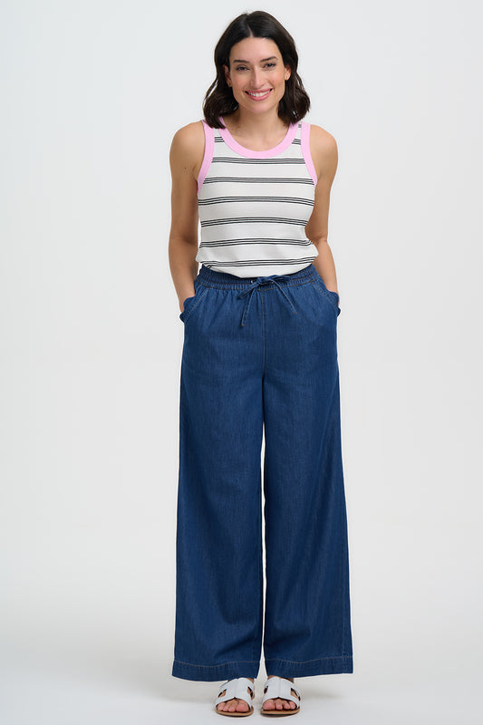 The Megan Trousers are a relaxed wardrobe staple crafted from 100% Responsibly Sourced cotton denim. Designed with comfort in mind, they feature a soft elasticated waistband with adjustable drawstring tie for the perfect fit. The full-length wide leg silhouette creates an easy, flattering drape, while the lightweight denim makes them ideal for everyday wear. Finished in a versatile deep blue wash, they pair effortlessly with simple tees, tanks or lightweight knits for a laid-back yet polished look.