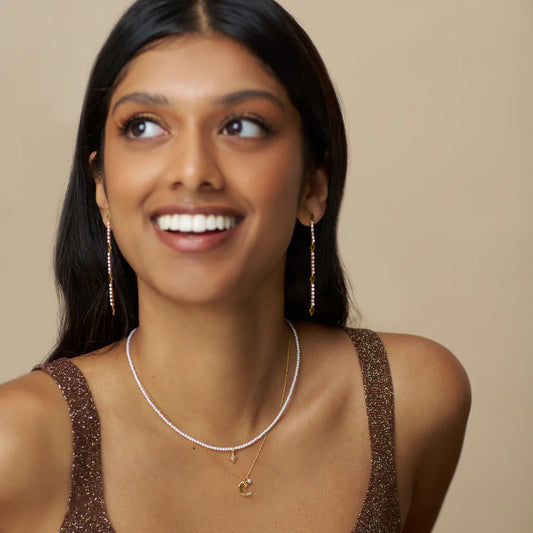 Bring a contemporary twist to classic elegance with the Micro Pearl &amp; Pavé Starburst Necklace. A chain of micro pearls are paired with pavé starburst charm, that sits delicately at the collar one. This piece creates a modern, refined take on pearl jewellery and reimagining a once classic trend.