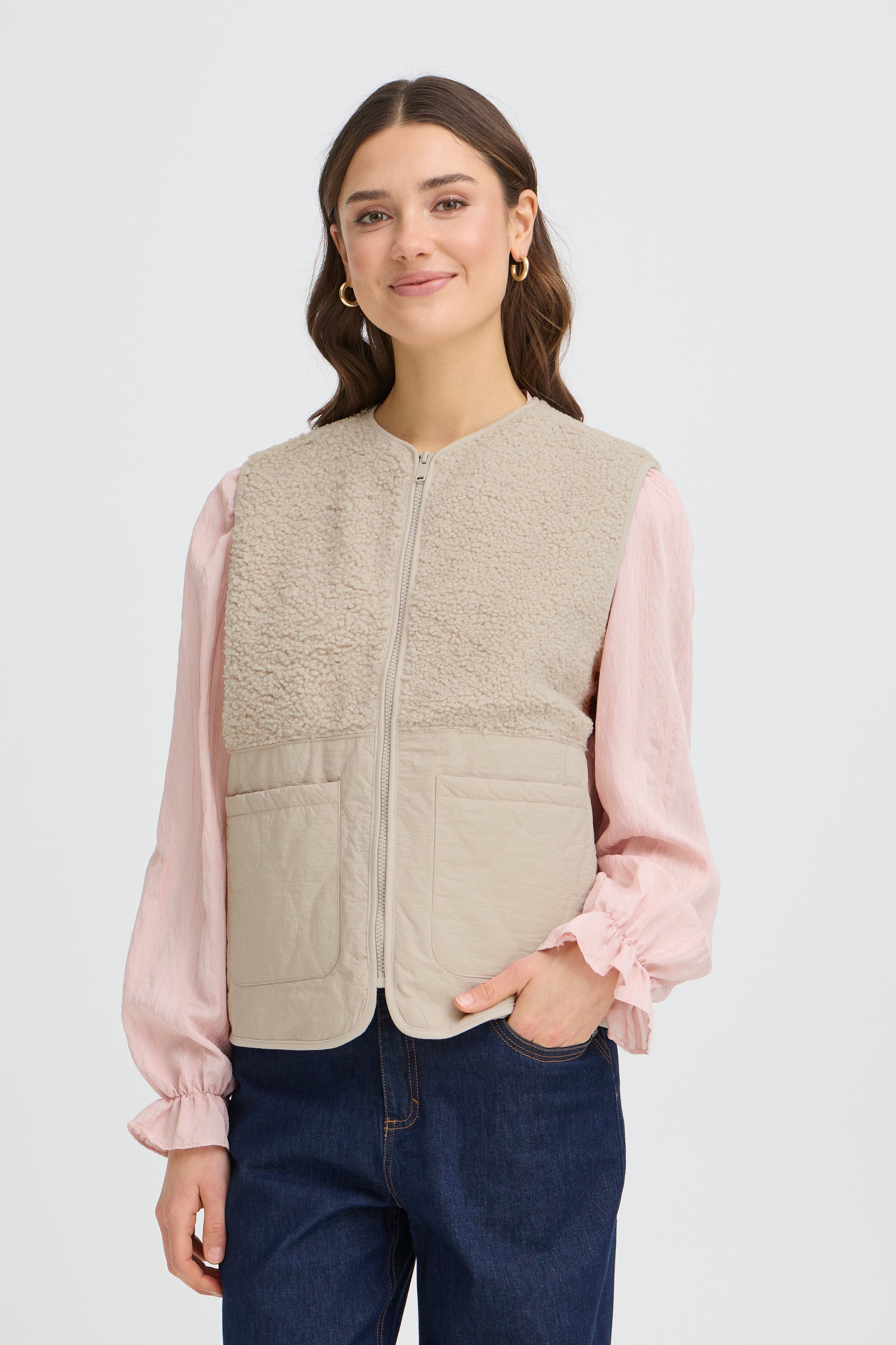 The FRANSA Mikala Waistcoat is a versatile layering essential designed for spring styling. This relaxed-fit vest features a convenient zip closure, making it effortless to adjust throughout the day. The sophisticated neutral hue pairs seamlessly with sweaters, blouses, and lightweight knitwear, offering endless outfit combinations. Whether you're layering for warmth or adding visual interest to your look, this waistcoat delivers both comfort and contemporary style