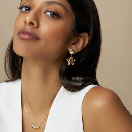 The Statement Molten Star Earrings are crafted in a molten-inspired texture and adorned with glimmering crystals. These statement earrings feature a star pendant drop, suspended from a round coin for a bold, celestial-inspired look. Pair with a subtle necklaces or delicate bracelets, and let these earrings remain the focal point.The Statement Molten Star Earrings are crafted in a molten-inspired texture and adorned with glimmering crystals.