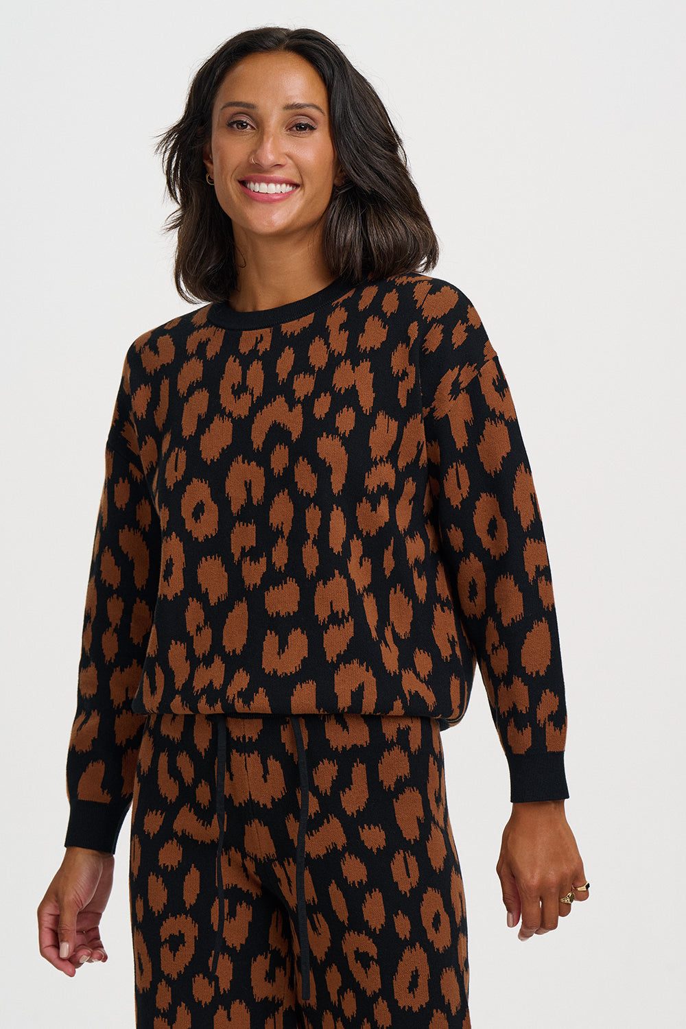 A leopard print done properly, this jumper from SUGARHILL brings a bold and timeless animal print with a painterly twist. Classic leopard spots in rich chocolate brown are rendered with a slightly textured, brushed edge against a deep black background, giving this wardrobe staple a raw, instinctive energy.