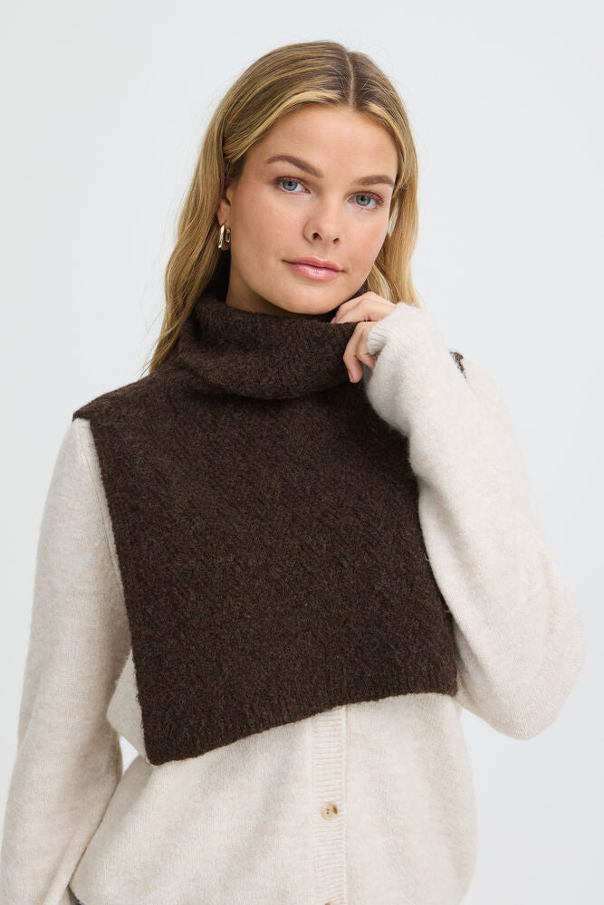 This versatile accessory ffrom FRANSA eatures a high, structured collar that adds a refined touch to any outfit. Its textured surface provides visual interest and a cozy feel, making it an ideal layering piece for cooler days. The design is simple yet impactful, offering an effortless way to enhance your wardrobe.
