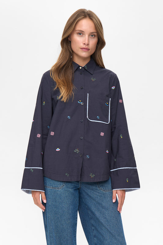 A fantastic addition to any Winter wardrobe from our gorgeous Scandi brand NUMPH. A boxy shaped shirt with a slightly curved hem and long sleeves . The sleeves have a large cuff with a striped lining that can be turned back to create another look. There is a flower shaped metal button at the collar and simple navy buttons to close. The beautiful embroidery all over is very much Numph styling, classic with that point of difference.